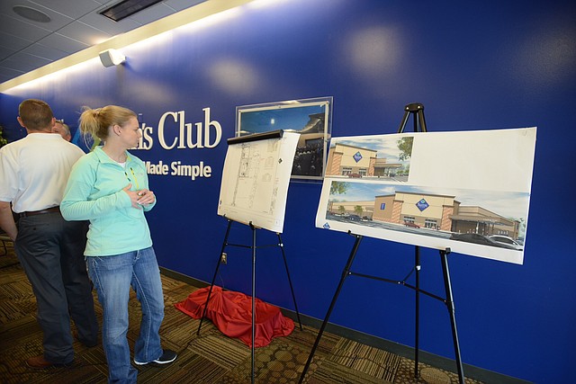 Sarah Gordley, Vice President of organizational management for the Springdale Chamber of Commerce, looks at a map and renderings of a new Sam's Club slated to be built near West Sunset and 56th Street in Springdale. 
