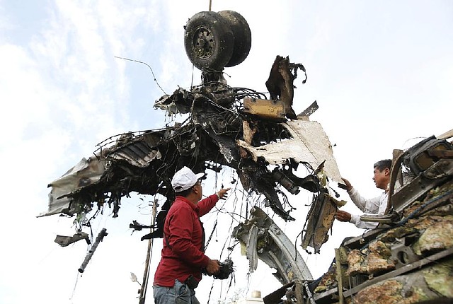 Emergency workers remove the wreckage of a TransAsia Airways flight after last month’s crash in Taiwan. Some trouble spots in air travel safety are in areas where such travel is growing the fastest.