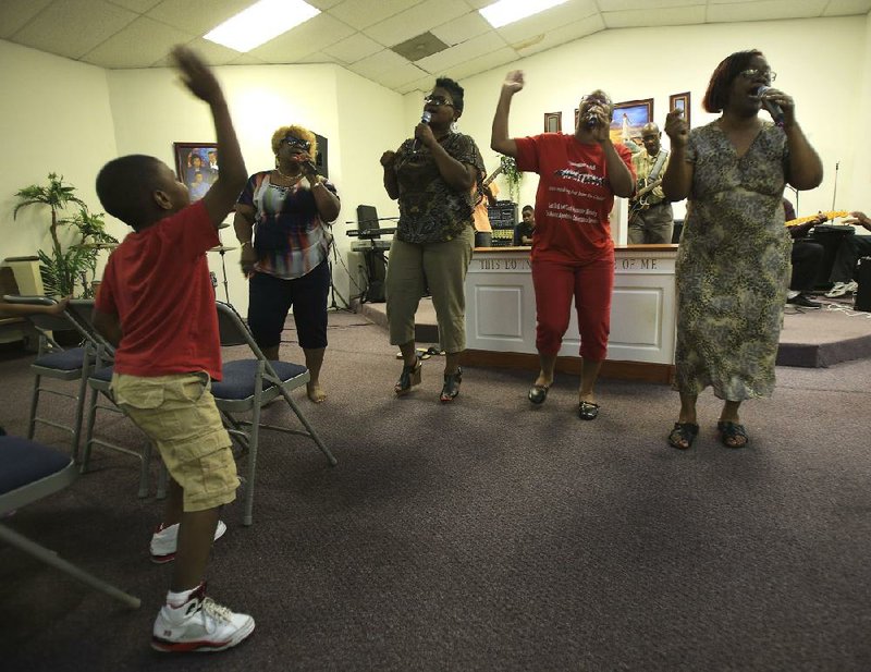  Arkansas Democrat-Gazette/STATON BREIDENTHAL --7/22/14-- Kavion Smith, 5, dances as (left to right)  Ceola Bailey, La-Kisha Smith, Tamika Myers and Lenora Harris sing a song during rehearsal with the Golatt Links of Harmony gospel group Tuesday night in Little Rock. The family group has been singing together for 50 years. 