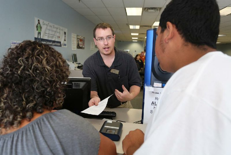 Immigrant and longtime resident in the United States Rosalva Mireles, left, is processed for her permanent driver's license at a Department of Motor Vehicles office, in Denver, Friday Aug. 1, 2014. Colorado began issuing driver's licenses and identification cards on Friday to immigrants who are in the country, regardless of legal immigration status. (AP Photo/Brennan Linsley)