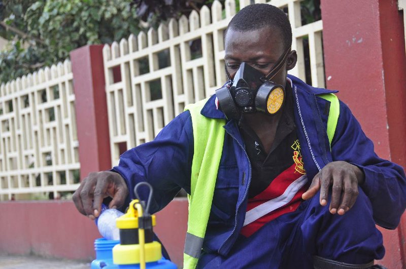 An employee  of the Monrovia City Corporation mixes disinfectant before spraying it on the streets in a bid to prevent the spread of  the deadly Ebola virus, in the city of Monrovia, Liberia, Friday, Aug. 1, 2014. U.S. health officials warned Americans not to travel to the three West African countries hit by the worst recorded Ebola outbreak in history. The travel advisory issued Thursday applies to nonessential travel to Guinea, Liberia and Sierra Leone, where the deadly disease has killed more than 700 people this year. (AP Photo/Abbas Dulleh) 