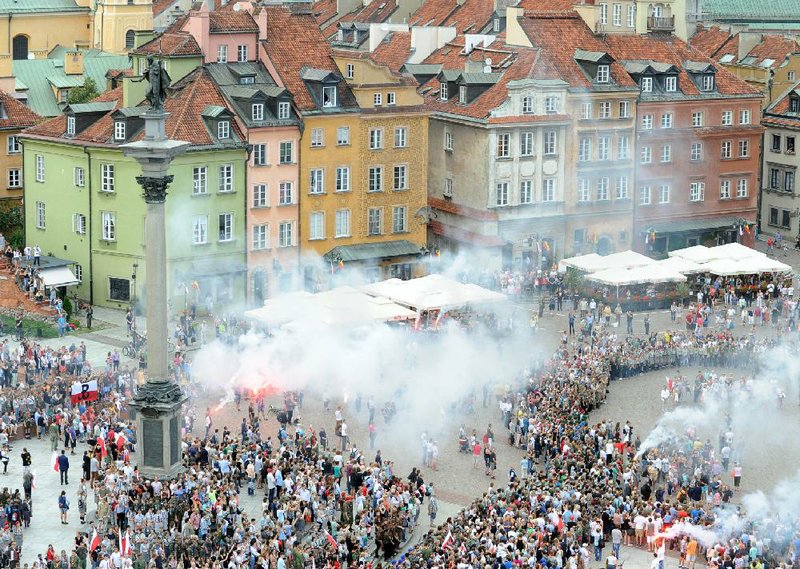 People attend a minute of silence to commemorate the 70th anniversary of the 1944 Warsaw Uprising in Warsaw, Poland, Friday, Aug. 1, 2014. On Aug. 1, 1944, thousands of poorly-armed young city residents rose up against the German forces to try to take control of Warsaw ahead of the advancing Soviet army. They held on for 63 days in the cut-off city before being forced to surrender. Almost 200,000 fighters and civilians were killed in street fights and in German bombings. The Nazis expelled the survivors and set the city ablaze. (AP Photo/Alik Keplicz)