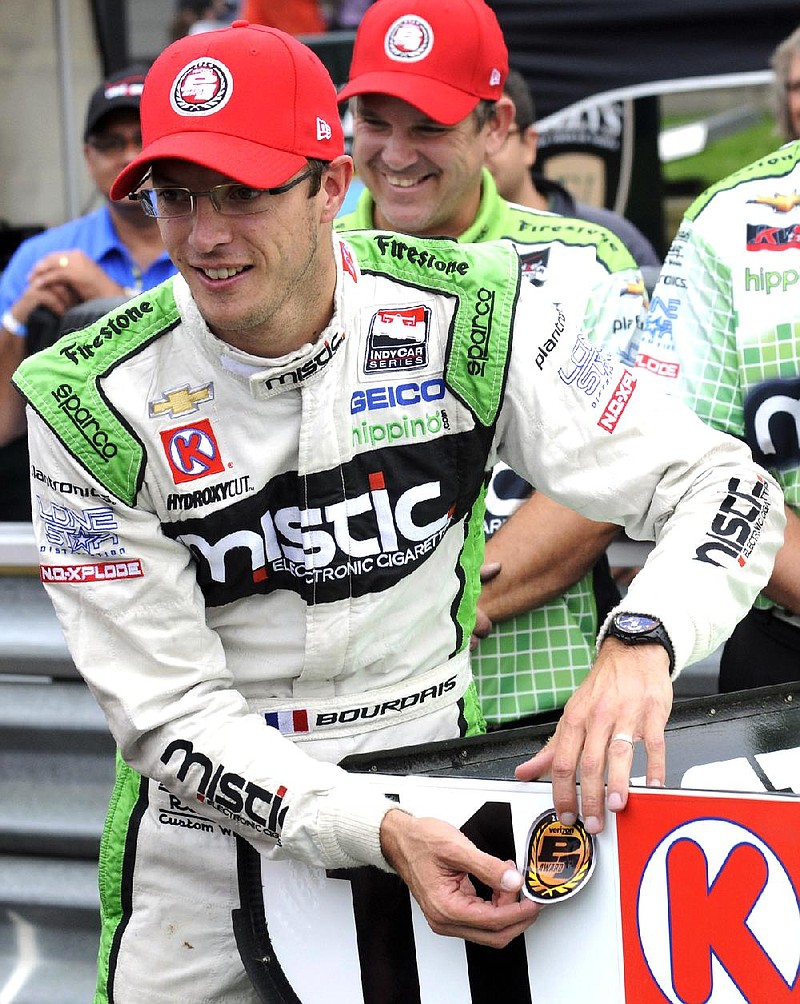 Sebastien Bourdais, of France, places the pole position sticker on the wing of his car after winning the pole for Sunday's IndyCar Honda Indy 200 auto race at Mid-Ohio Sports Car Course in Lexington, Ohio, Saturday, Aug. 2, 2014. (AP Photo/Tom E. Puskar)
