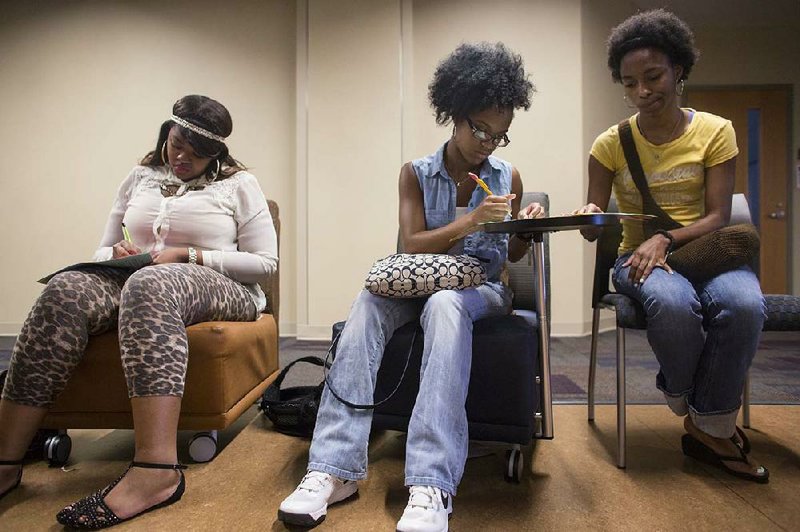 Countess Jenkins (from left), Leah Akins and Natasha Wilbon do writing exercises Wednesday under the instruction of Harold Brown during a session at the Dr. Charles W. Donaldson Summer Bridge Academy.