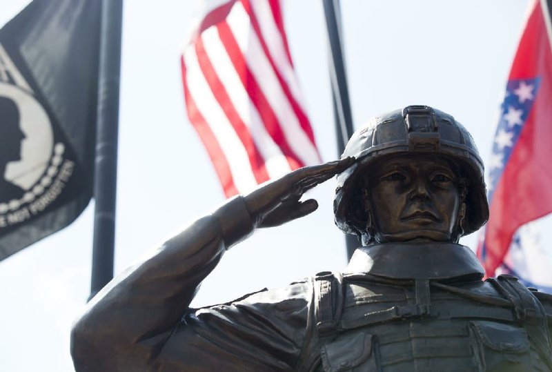 A statue of a Desert Storm soldier is dedicated Saturday outside My Friend’s Place bar and grill at Military and MacArthur drives in North Little Rock.