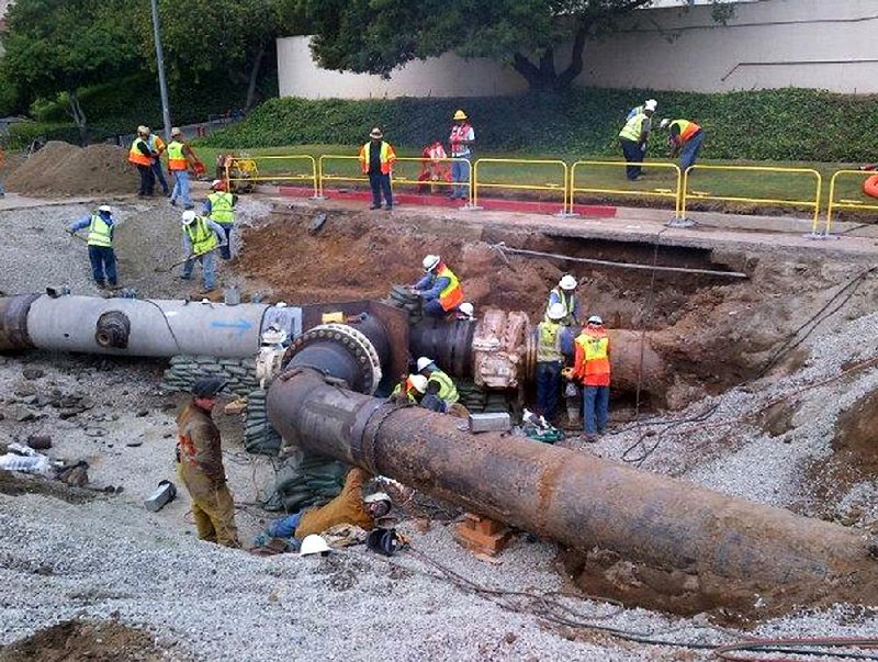 This image provided by the Los Angeles Department off Water and Power shows workmen putting together the replacement pipe before final testing on Saturday Aug. 2, 2014, in Los Angeles. Crews have finished repairs on an old water main that burst and poured 20 million gallons of water onto the UCLA campus. (AP Photo/LADWP)
