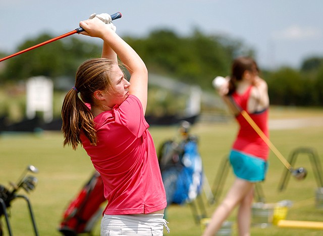 Rogers Heritage freshman Chloe Kordsmeier hits from the driving range during practice on Tuesday, July 29, 2014, at The First Tee of Northwest Arkansas in Lowell.