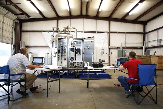 NWA Media/DAVID GOTTSCHALK - 7/30/14 - Robert Hime, with Bear Automation, left, and Darryl Fendley, senior product engineer with BlueinGreen,  continues to prepare a CDOX for delivery to Omaha Ne., at their manufacturing facility in Fayetteville Wednesday July 30, 2014.
