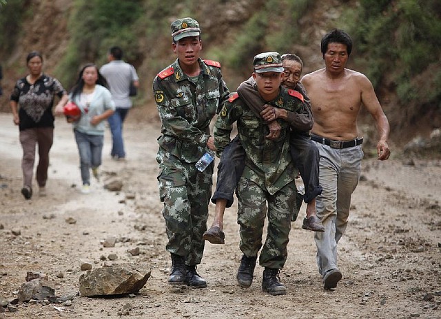 In this photo released by China's Xinhua News Agency, rescuers transport injured people after an earthquake in Zhaotong City in the densely populated Ludian county in southwest China's Yunnan Province, Sunday Aug. 3, 2014.  The strong earthquake in southern China's Yunnan province toppled thousands of homes on Sunday, killing at least 175 people and injuring more than 1,400, according to China's official Xinhua News Agency. (AP Photo / Xinhua, Zhang Guangyu) NO SALES