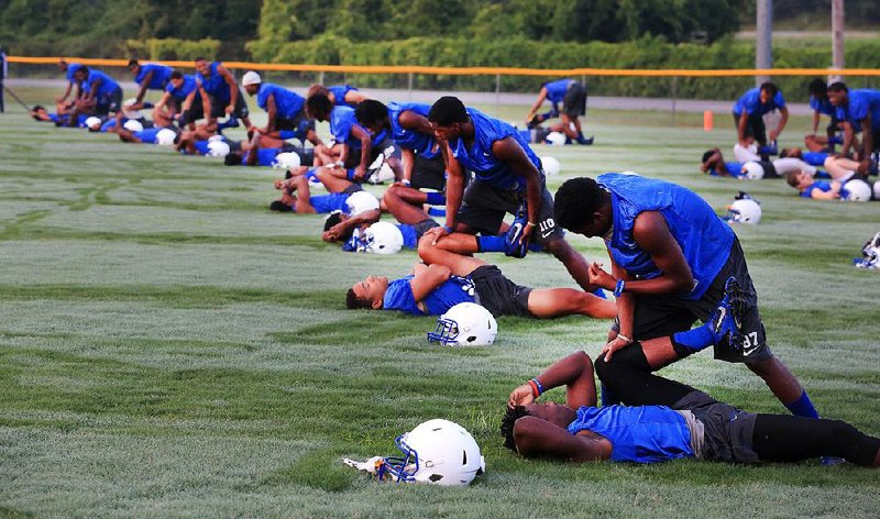 Arkansas Democrat-Gazette/RICK MCFARLAND--08/04/14--    North Little Rock football players do stretching exercises during their first practice early Monday morning in Burns Park.