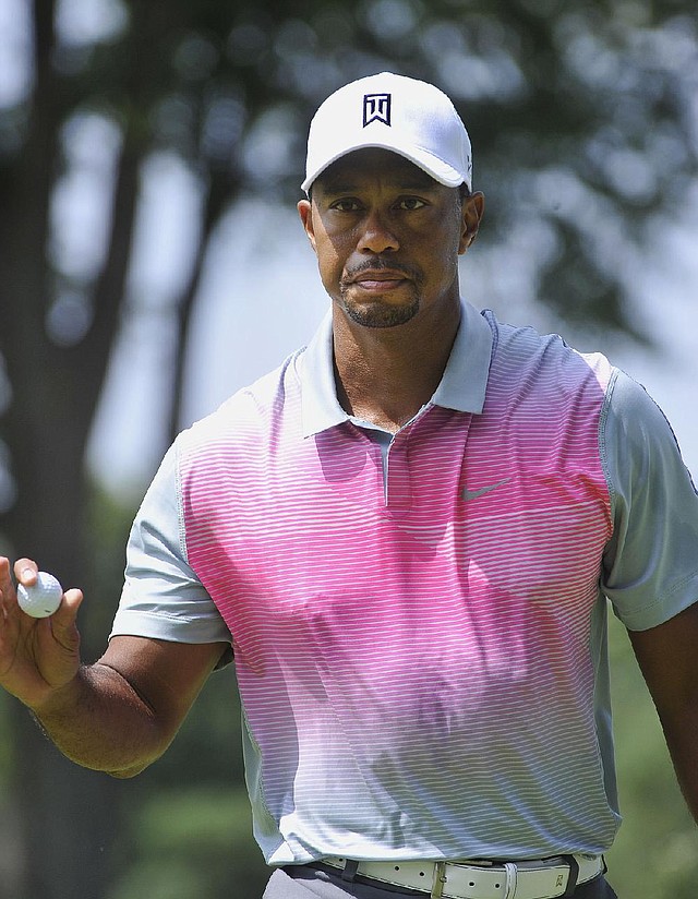 Tiger Woods gives a small wave after a birdie on the second hole, during the first round of the Bridgestone Invitational golf tournament, Thursday, July 31, 2014, in Akron, Ohio. (AP Photo/Phil Long)