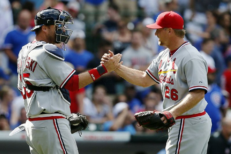 St. Louis Cardinals catcher A.J. Pierzynski and relief pitcher Trevor Rosenthal celebrate after defeating the Chicago Cubs in a baseball game on Sunday, July 27, 2014, in Chicago. The St. Louis Cardinals won 1-0. (AP Photo/Andrew A. Nelles)