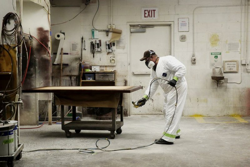 An employee stains a tabletop last week at the Northland Furniture Co. in Bend, Ore. Factory orders rose in June, led by demand for aircraft, the Commerce Department reported.