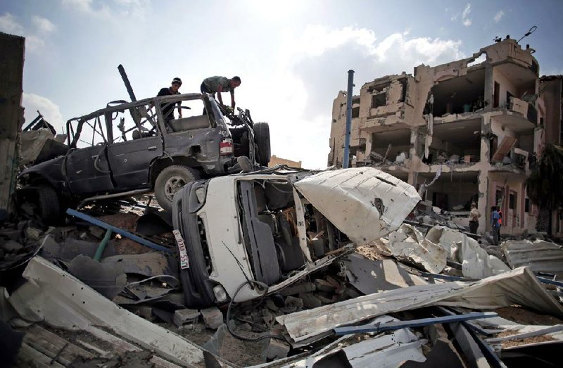 Palestinians search through a jumble of vehicles Tuesday in the hard-hit Shawkah district of Rafah in southern Gaza. 