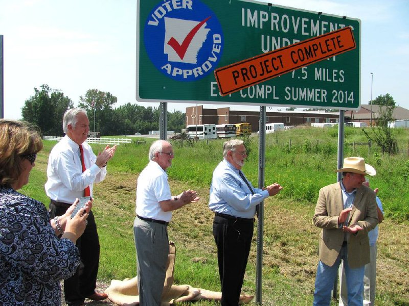 Officials unveil a sign Tuesday proclaiming the completion of the Interstate 540 reconstruction in Fort Smith and Van Buren. The $78 million contract was the largest in Arkansas Highway and Transportation Department history. From left are Fort Smith City Administrator Ray Gosack, Arkansas Highway Commissioner Dick Trammel, Fort Smith Mayor Sandy Sanders and 9th District state Sen. Bruce Holland, R-Greenwood.