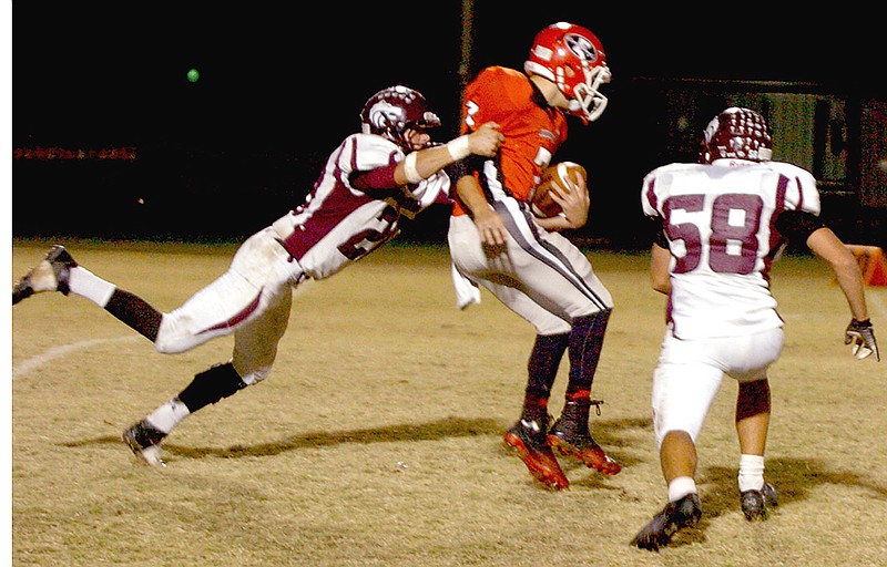 MARK HUMPHREY ENTERPRISE-LEADER Linebacker blitz. Mikie Drain sacks Farmington quarterback Keaton Austin after blitzing while Wolf defensive end Charles Rowe races in to help. Drain was selected for All-Conference honorable mention in 2013.