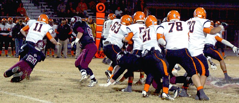 MARK HUMPHREY ENTERPRISE-LEADER Nashville has a wall of blockers set up but Lincoln linebacker Johnny Yang defeats the play by diving in to make a tackle behind the line of scrimmage during the 2013 state 4A playoffs. Lincoln defeated Nashville, 27-13, and Yang was rewarded with All-Conference honors.