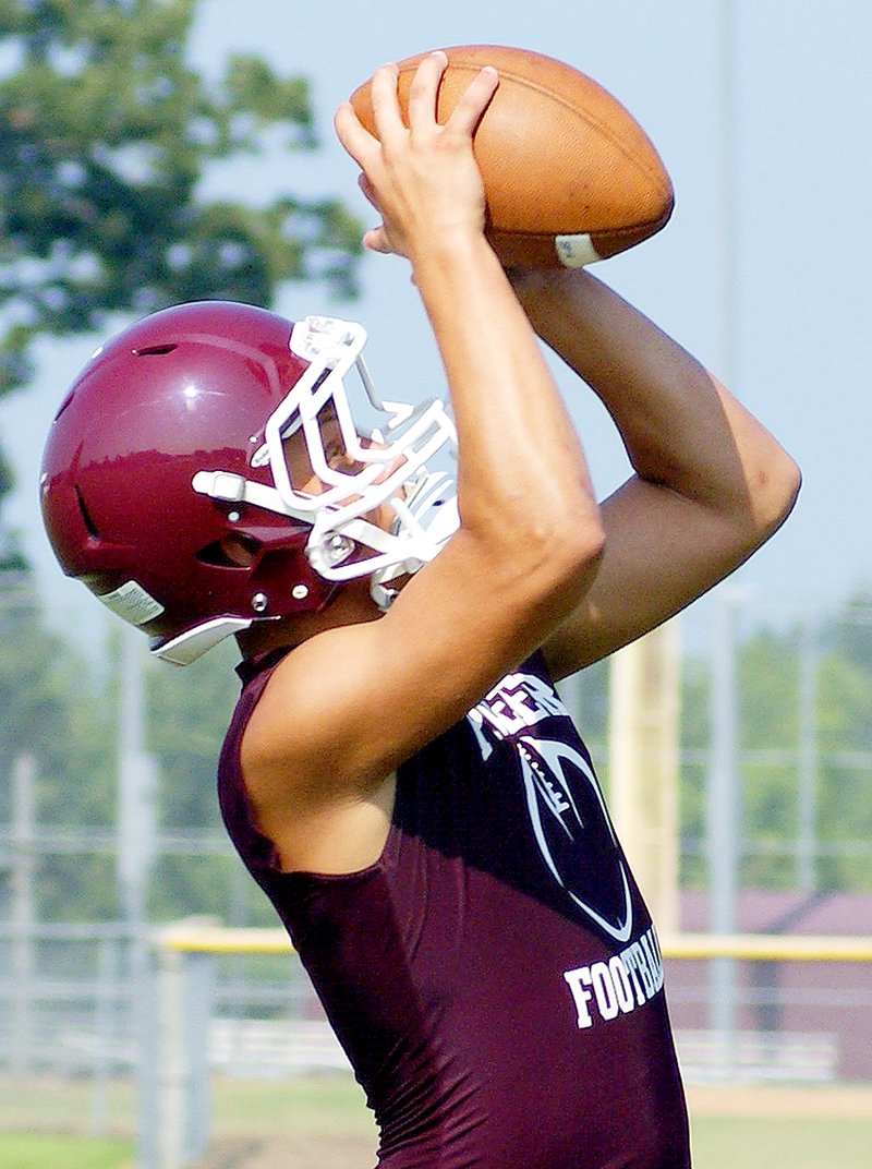 Photo by Randy Moll Gentry junior Dillon Matthews goes up to catch a pass during the first official day of football practice at Gentry High School on Monday. Daily practices will now continue to ready players for the upcoming season.