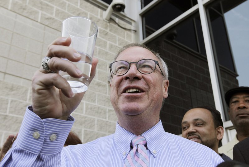 Toledo Mayor D. Michael Collins raises a glass of tap water before drinking it during a news conference in Toledo, Ohio, Monday, Aug. 4, 2014. A water ban that had hundreds of thousands of people in Ohio and Michigan scrambling for drinking water has been lifted, Collins announced Monday.