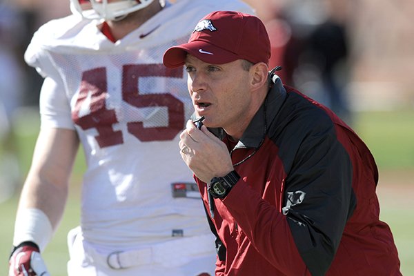 Arkansas defensive coordinator Robb Smith directs his players as linebacker Alex Brignoni listens during practice Thursday, March 20, 2014, at the UA practice field in Fayetteville.