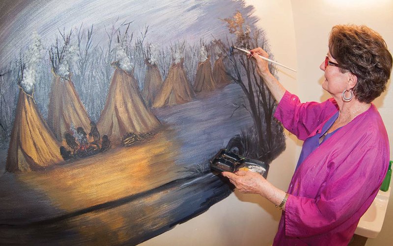 Fairfield Bay artist Doris Sexson works on a mural in the restroom of the Log Cabin Museum at the Indian Hills Country Club in Fairfield Bay. The mural depicts Native Americans and their tepees.