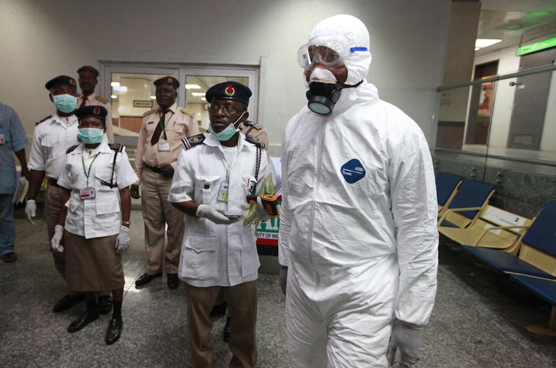 In this Monday, Aug. 4, 2014, file photo, Nigerian health officials wait to screen passengers at the arrival hall of Murtala Muhammed International Airport in Lagos, Nigeria. A Nigerian nurse who treated a man with Ebola is now dead and five others are sick with one of the world's most virulent diseases, authorities said Wednesday. 