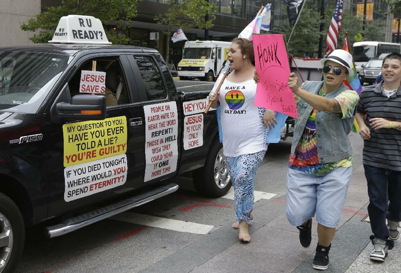 Gay-marriage supporters confront an opponent driving his truck around Fountain Square in Cincinnati where supporters held a rally Wednesday as a federal appeals panel heard six gay-marriage cases. 