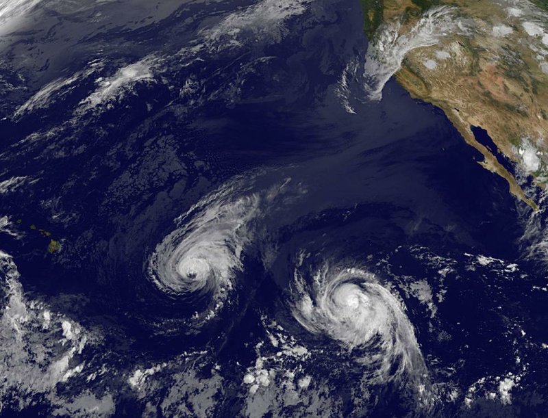 This image provided by NOAA taken Wednesday shows Hurricane Iselle (left) and Hurricane Julio. Iselle, spinning nearer the Hawaiian Islands, has strengthened rather than weakened, forecasters said. 