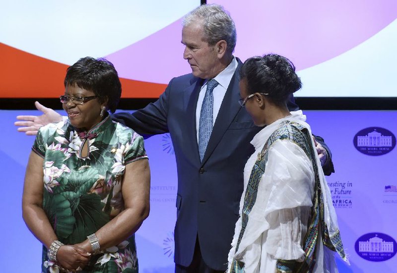 Former President George W. Bush takes the stage Wednesday at the Kennedy Center in Washington with Namibian first lady Penehupifo Pohamba (left) and Ethiopian first lady Roman Tesfaye.
