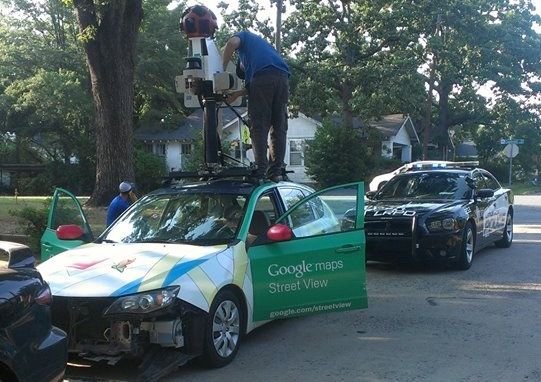 A Google Street View driver checks his equipment after he hit another car while trying to turn onto Cantrell Road on Wednesday evening.