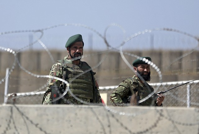 Afghanistan National Army soldiers stand guard at a gate of Camp Qargha, west of  Kabul, Afghanistan, Tuesday, Aug. 5, 2014. Earlier in the day, a man dressed in an Afghan army uniform opened fire on foreign troops at the military base, killing a U.S. two-star general and wounding others, among them a German brigadier general and a number of Americans troops, authorities said.