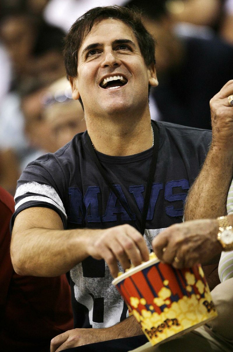 FILE -- This is a July 13, 2009, file photo showing Dallas Mavericks owner Mark Cuban looking at the scoreboard while eating popcorn and watching his team from the sidelines during an NBA summer league basketball game in Las Vegas.  (AP Photo/Laura Rauch, File)