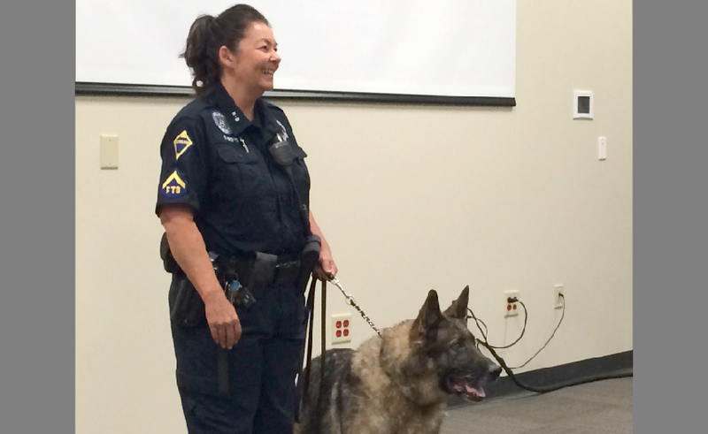 Regina Boyd, K-9 instructor for the Jacksonville Police Department, stands with her police dog, Roby, at his retirement ceremony on Friday. The 10-year-old German shepherd has been with the department since 2008. 