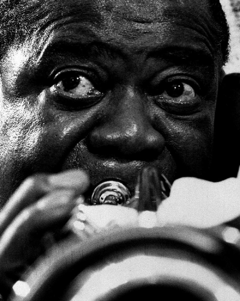 Louis Armstrong practices on a gold-plated trumpet in 1970.