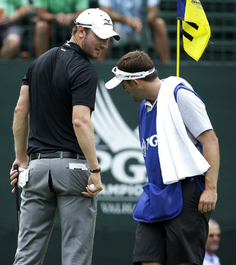 Chris Wood show a rip in his pants to his caddie on the 11th hole during the first round of the PGA Championship golf tournament at Valhalla Golf Club on Thursday, Aug. 7, 2014, in Louisville, Ky. (AP Photo/Jeff Roberson)