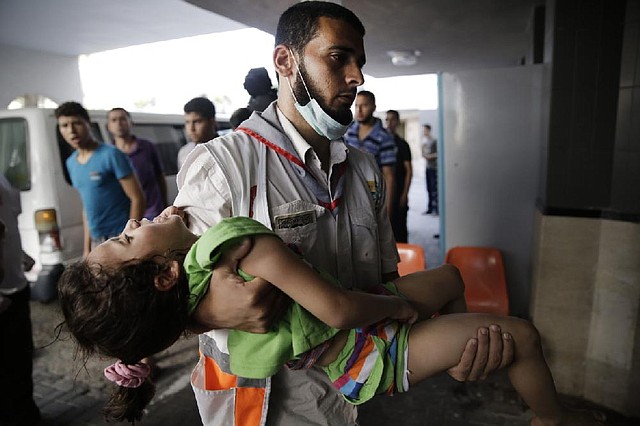 A Palestinian medic carries a wounded girl into the Shifa hospital in Gaza City after Hamas and Israel resumed cross-border attacks Friday after a three-day truce.