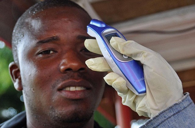 A man's temperature is measured before he is allowed into a business center, as fear of the deadly Ebola virus spreads through the city of Monrovia, Liberia, Saturday, Aug. 9, 2014. Over the decades, Ebola cases have been confirmed in 10 African countries, including Congo where the disease was first reported in 1976. But until this year, Ebola had never come to West Africa. (AP Photo/Abbas Dulleh)
