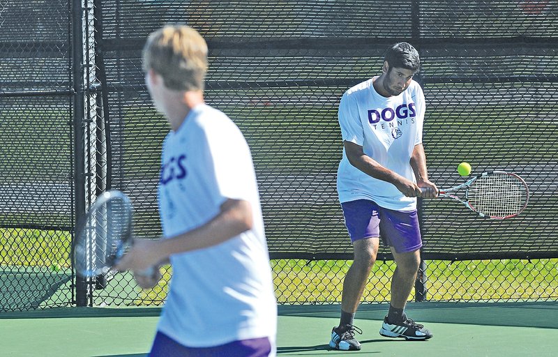 STAFF PHOTO SAMANTHA BAKER &#8226; @NWASamantha Sameer Kamath, right, Fayetteville senior, volleys the serve back to opponents from Bentonville on Oct. 10 during the Boys 7A-West Tennis Tournament at Memorial Park in Bentonville. Kamath is the defending Class 7A state doubles champion and returns as a team leader for Fayetteville this season.