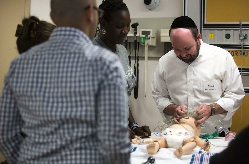 Arkansas Democrat-Gazette/Melissa Sue Gerrits - 07/19/2014 - Mark Shlomovich pretends to apply an ice packet on a mannequin during Standardized Patient/ Mannequin bootcamp July 19, 2014 at the PULSE Center at Arkansas Children's Hospital where the doctors are able to practice operating on mannequins and giving bad news to mock "parents." 