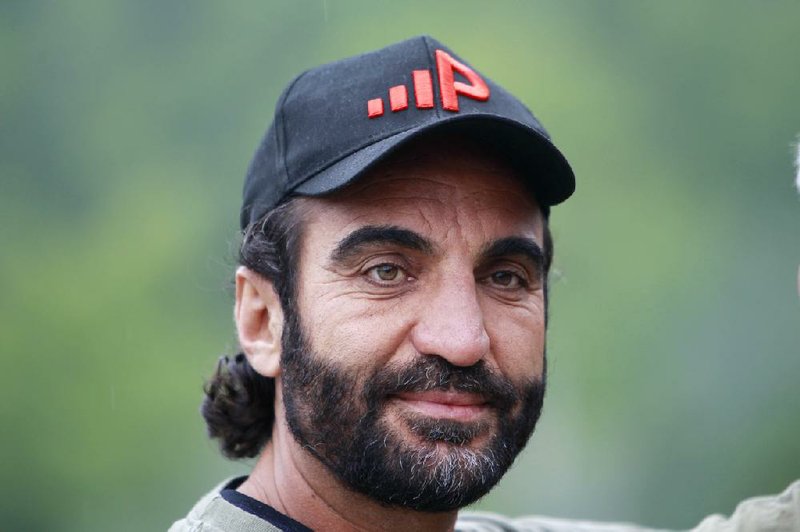 In this photo taken Wednesday Aug. 6, 2014, Afghan native Fahim Fazli, is seen at the base of Mount Washington, N.H. before ascending the mountain via the Ammonoosuc Ravine Trail. Fazli has written a book he hopes to turn into a movie about his life as an Afghan native who fled his country, became a U.S. Citizen, a Hollywood actor who played roles as a Middle eastern terrorist, and returned to Afghanistan to be a translator for U.S. Marines. The two hiked Mount Washington in hopes the Presidential Range would be a stand in for a movie for  Asia's Hindu Kush mountains. (AP Photo/Jim Cole) 