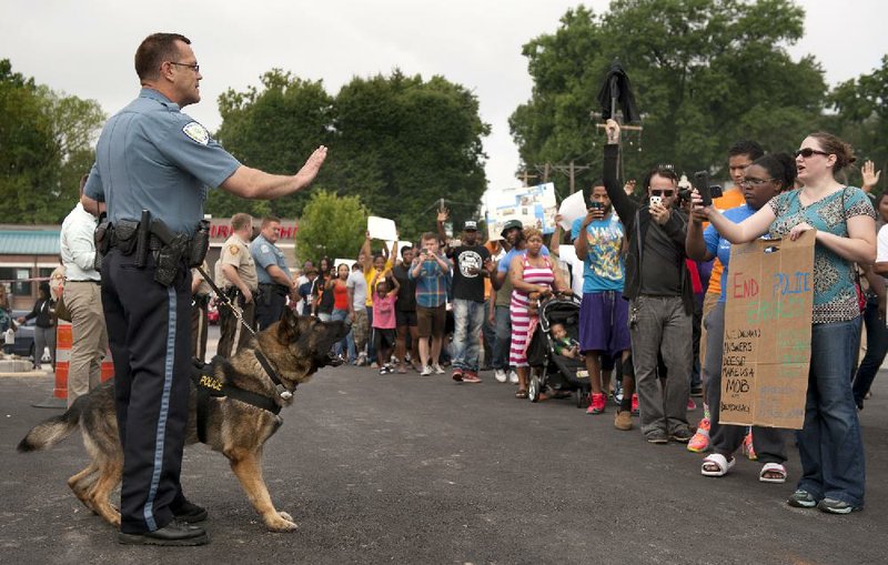 Protestors confront police during an impromptu rally, Sunday, Aug. 10, 2014 to protest the shooting of Michael Brown, 18, by police in Ferguson, Mo.  Saturday, Aug. 9, 2014. Brown died following a confrontation with police, according to St. Louis County Police Chief Jon Belmar, who spoke at a news conference Sunday. (AP Photo/Sid Hastings)