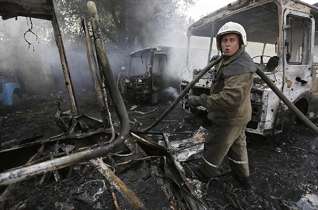 Ukrainian fire fighters put out the fire at the destroyed buses after shelling in Donetsk, eastern Ukraine, Sunday, Aug. 10, 2014. Fighting raged Sunday in the eastern Ukrainian city of Donetsk despite a request from the pro-Russian rebels there for a cease-fire to prevent a "humanitarian catastrophe." One person was killed and 10 injured in shelling that started early Sunday morning and continued into the day, city council spokesman Maxim Rovinsky told The Associated Press. (AP Photo/Sergei Grits)