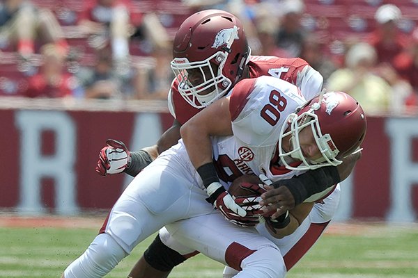 Arkansas receiver Drew Morgan (80) is tackled by linebacker Braylon Mitchell during the Red-White Game on Saturday, April 26, 2014 at Razorback Stadium in Fayetteville. 