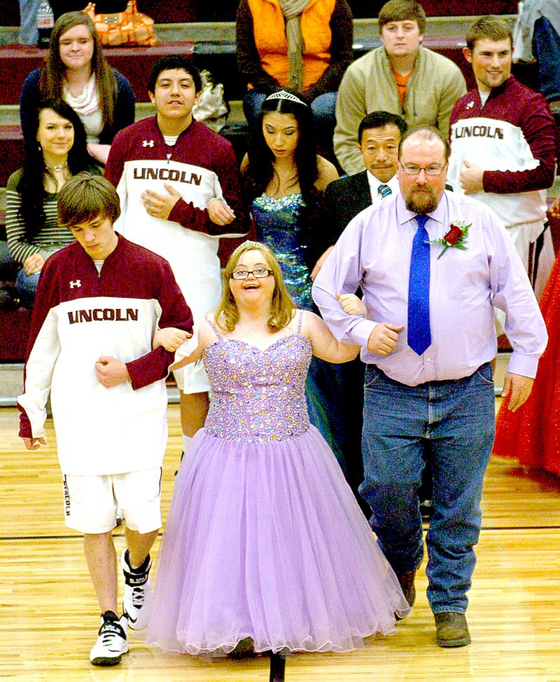 MARK HUMPHREY ENTERPRISE-LEADER Down Syndrome could not dash the dream of Kaylea Sandlin, daughter of Johnny and Susan Gilford, escorted by her father and senior Michael Eubanks, son of Charles and Sara Phillips, on her way to receiving the 2014 Lincoln Basketball Homecoming crown. Sandlin went on to graduate in May.
