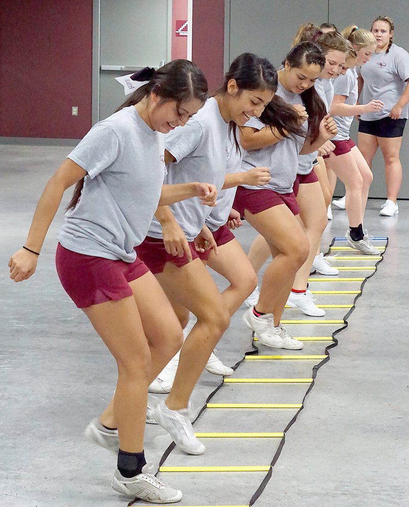 Photo by Randy Moll Members of the Gentry cheerleading squad warmed up before working on the mats during practice on Aug. 6 in the Pioneer Activities Complex.