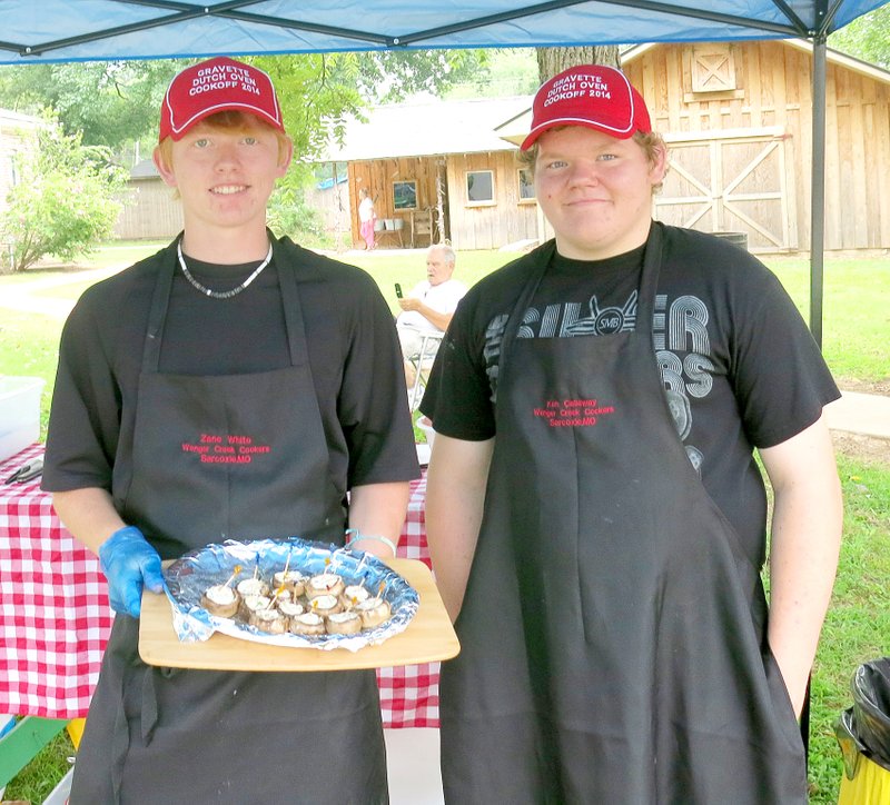 Photo by Susan Holland Keneth Callaway and Zane White, a pair of high school juniors from Sarcoxie, Mo., were the first-place team in the novice division at Saturday&#8217;s second annual Gravette Day Dutch-oven cook off. They won $30 for their entry of pot roast with kale and sweet potatoes. Here they display a plateful of stuffed mushrooms they were offering earlier in the day.