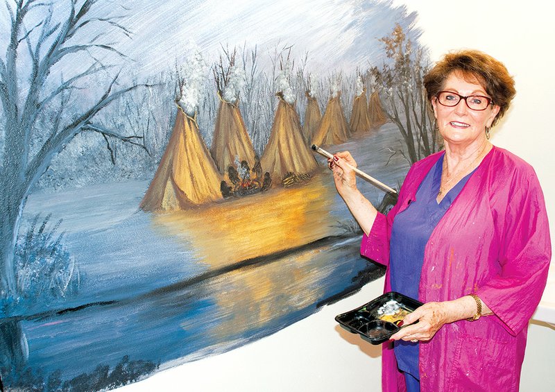 Fairfield Bay artist Doris Sexson works on a mural inside the restroom of the Log Cabin Museum at the Indian Hills Country Club in Fairfield Bay. The mural depicts Native Americans and their tepees.
