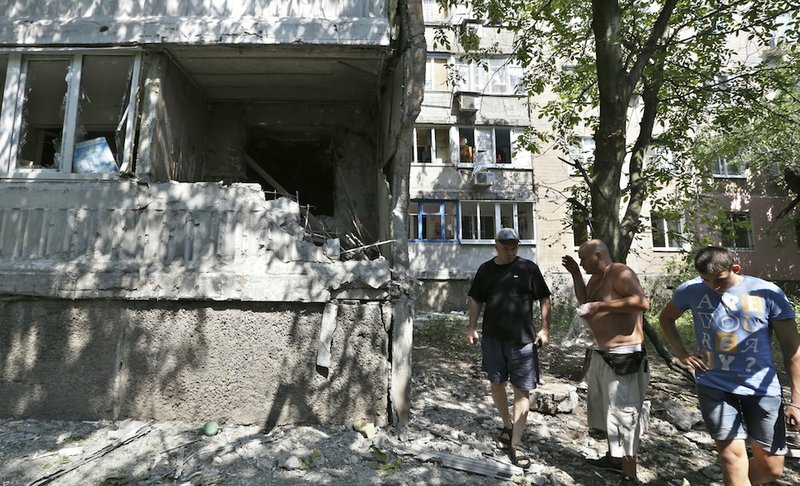 Residents react as they inspect the damage after shelling in Donetsk, eastern Ukraine, on Wednesday, Aug. 13, 2014. At least three people have been killed in the separatist-controlled city of Donetsk in eastern Ukraine as the government intensifies its shelling campaign. 