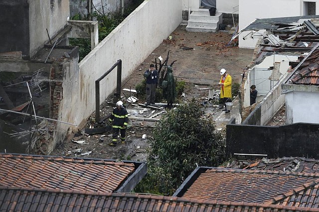 Emergency response officials work around the wreckage in the Brazilian port city of Santos where a small plane carrying presidential candidate Eduardo Campos crashed Wednesday, killing all seven people aboard. President Dilma Rousseff, who is seeking re-election, declared three days of mourning.