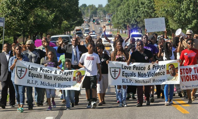 A march organized by area ministers to stop violence makes its way down West Florissant Avenue in Ferguson, Mo., on Wednesday.